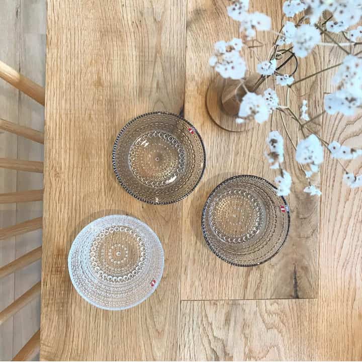 木目調のダイニングテーブルに透明なカステヘルミのボウルと白い花の花瓶が置かれた雰囲気のあるダイニング