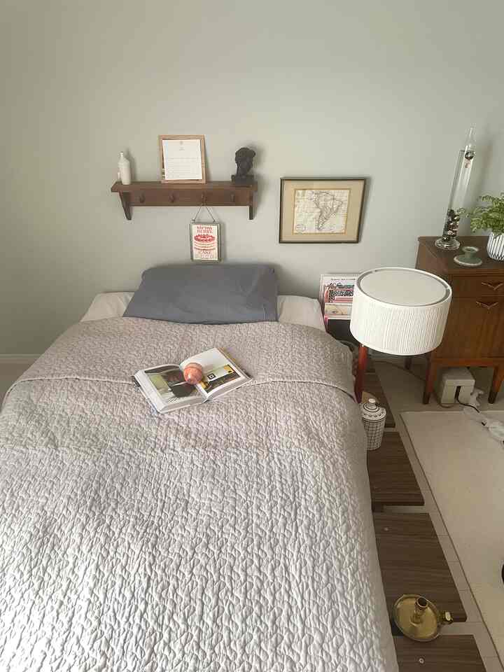 ベージュと木目調の寝室、木製ベッドフレームと柔らかな掛け布団カバーが配置された落ち着いた空間