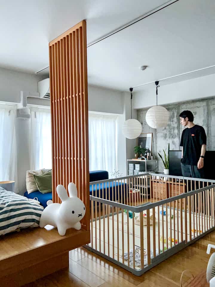 Bright wood tones and white natural living room featuring a central child safety gate and playmat creating a cozy space