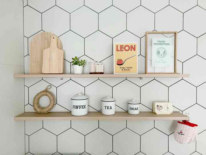 白いタイルの壁に木目調の棚が配置されたキッチンの棚、まな板やコーヒー用品が並ぶミニマルでナチュラルな雰囲気のインテリア