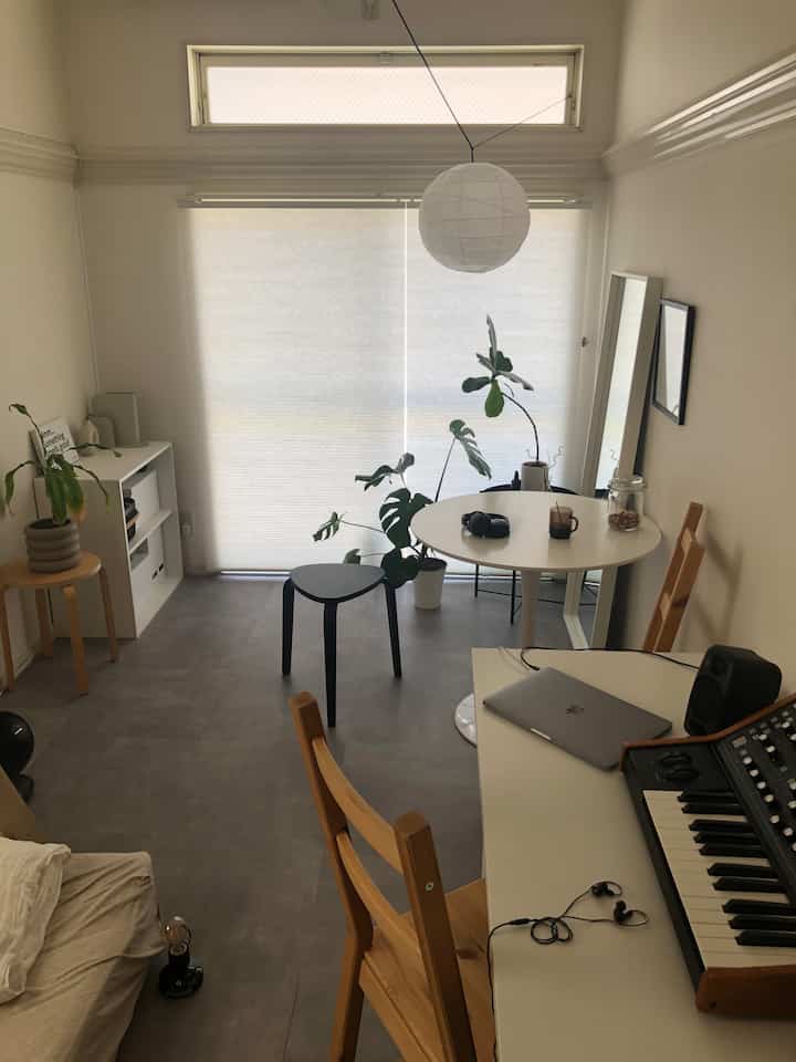 A beige and wood tone dominated single household home office featuring dining table and plants creating a natural atmosphere interior