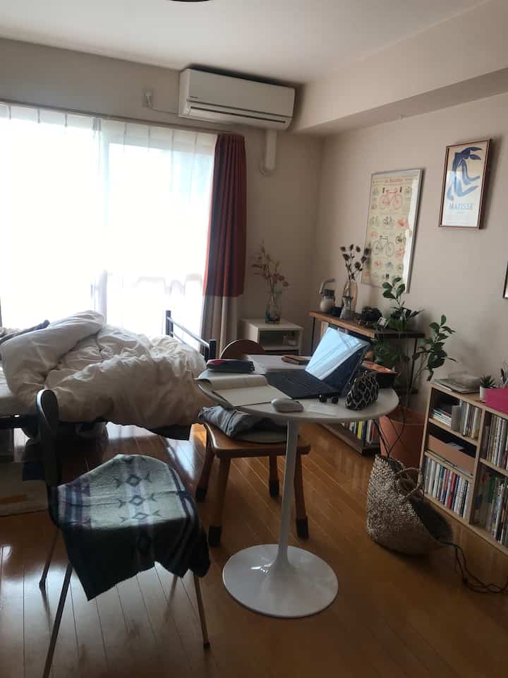 Natural wood tone flooring in a compact single household home office with a white round table