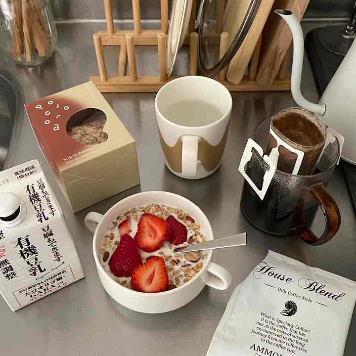 ステンレス製のキッチンカウンターにナチュラルな木製の皿立てとハンドドリップコーヒーセットが配置された雰囲気のあるキッチンスペース