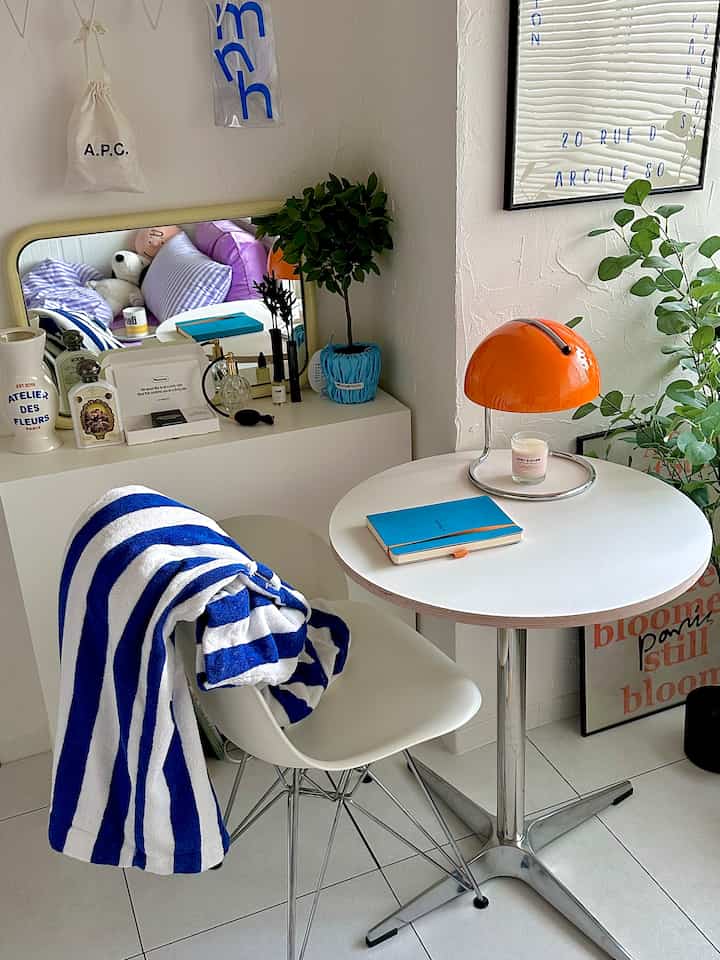 White and blue toned bedroom featuring a round table, cozy decor, and natural plants creating a warm atmosphere