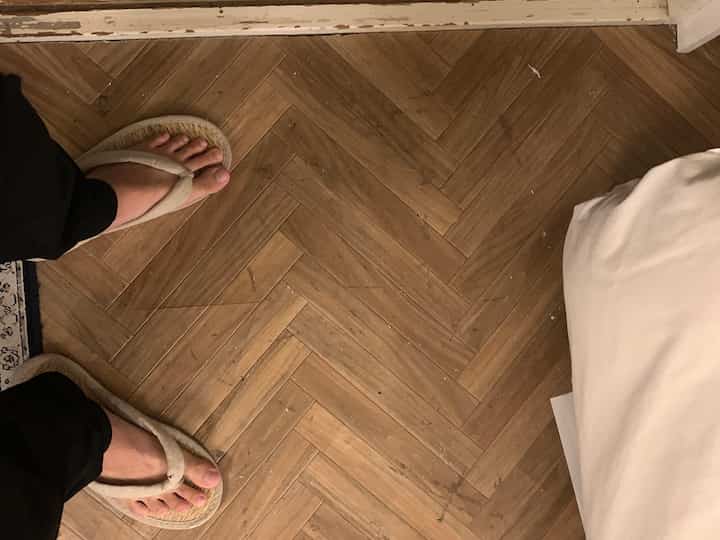 Natural tone wood floor with Muji igusa slippers in a warm studio apartment space