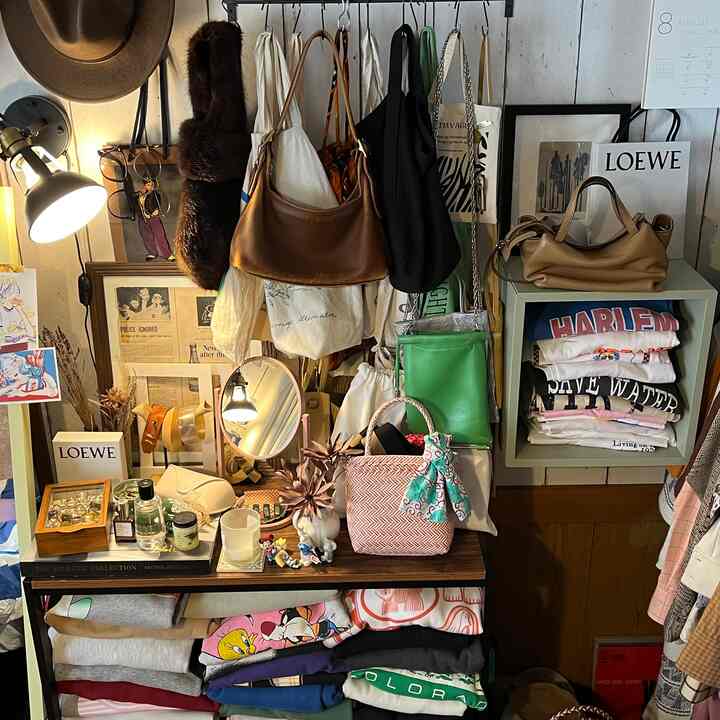 ブラウンとホワイトの色調の狭い部屋、レザーのバッグと収納棚が配置されたナチュラルでカフェ風のインテリア