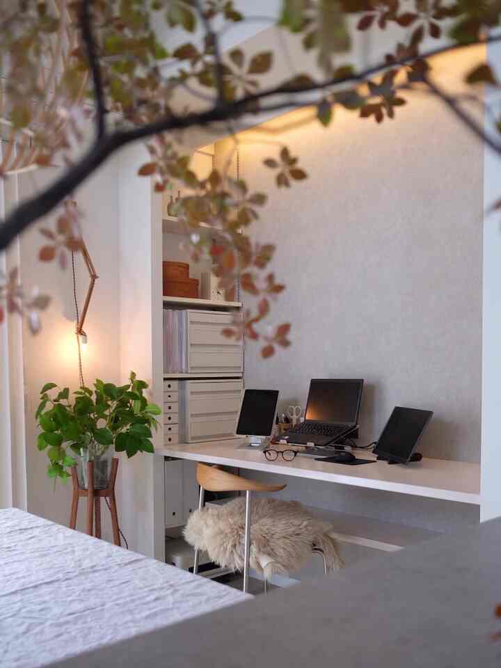 白と緑の色調が調和するホームオフィス、広いデスクと機能的なオフィスチェアが配置された快適な在宅勤務空間