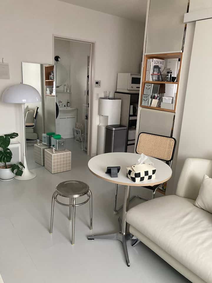 White-toned living room featuring a round table, stools, and a minimalist modern atmosphere