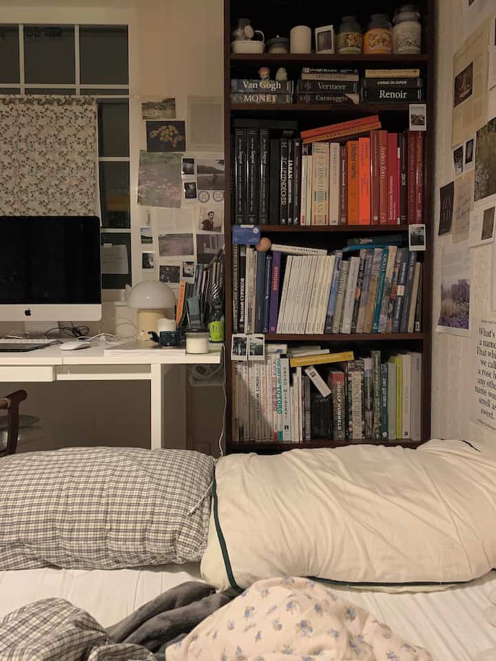 Natural color tone bedroom featuring an organized bookshelf and desk in a cozy setting