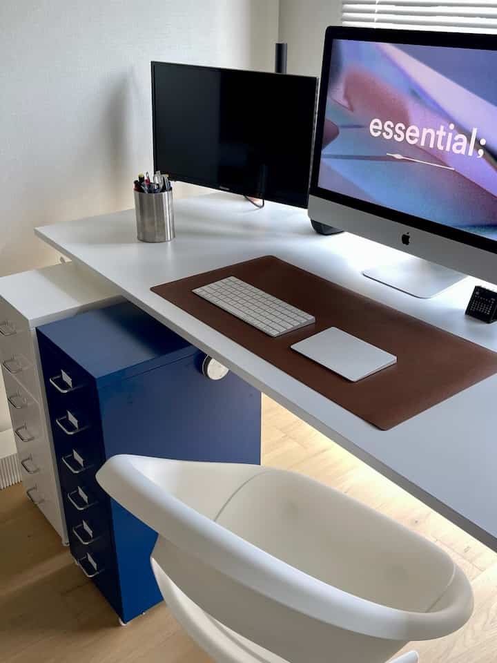 ホワイトとネイビートーンのホームオフィス、シンプルなデスクとチェア、IKEAの収納ユニットが配置された雰囲気のあるインテリア