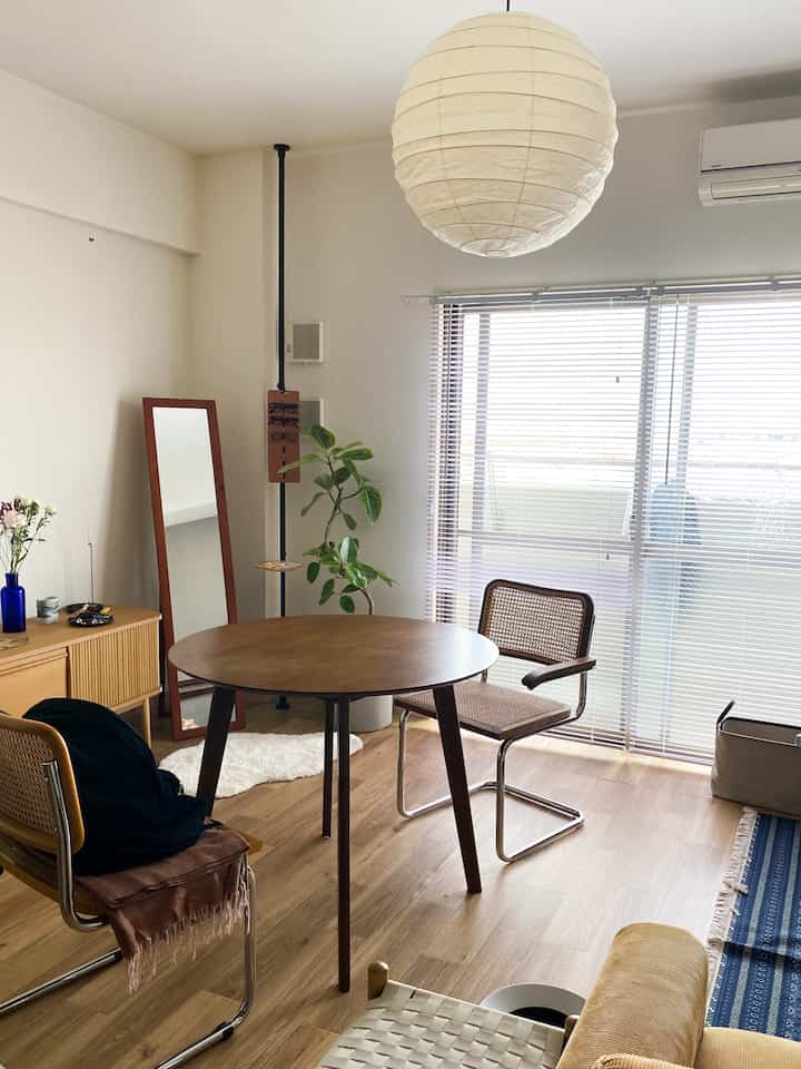 木目調と白を基調としたダイニングルーム、丸いテーブルとチェスカチェアが配置された自然で落ち着いた雰囲気のインテリア