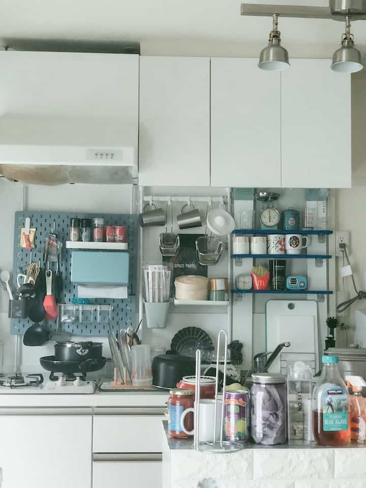 白を基調としたキッチン、壁面に収納された調理器具が印象的な清潔感とモダンな雰囲気の空間