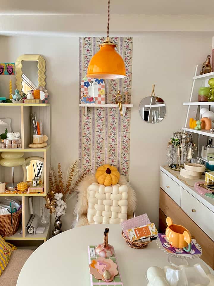 黄色とオレンジのトーンの1LDKリビング、かわいい小物とテーブルが配置された雰囲気のある空間