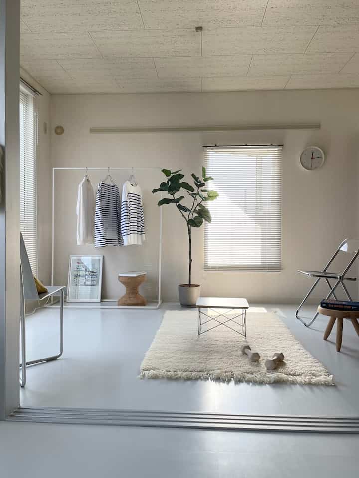 Bright living room in white and natural tones featuring a white coffee table and indoor plant in a minimalist setting