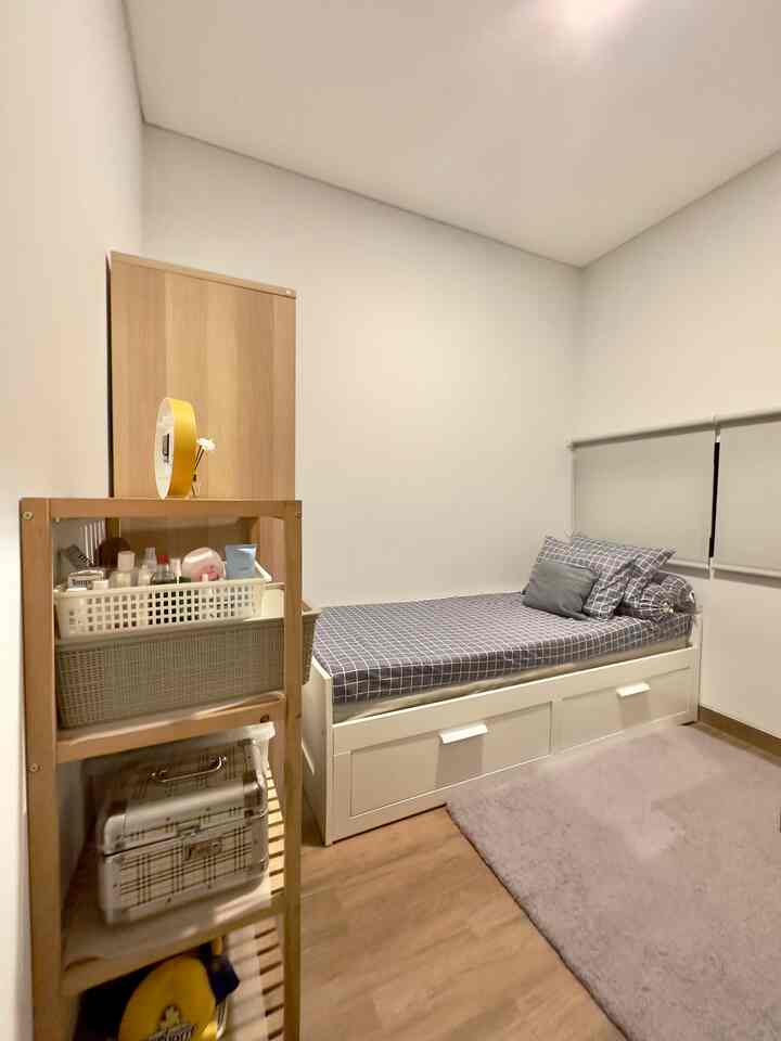 White-toned kids' room featuring brown wooden furniture and a single bed, creating a neat and compact practical space