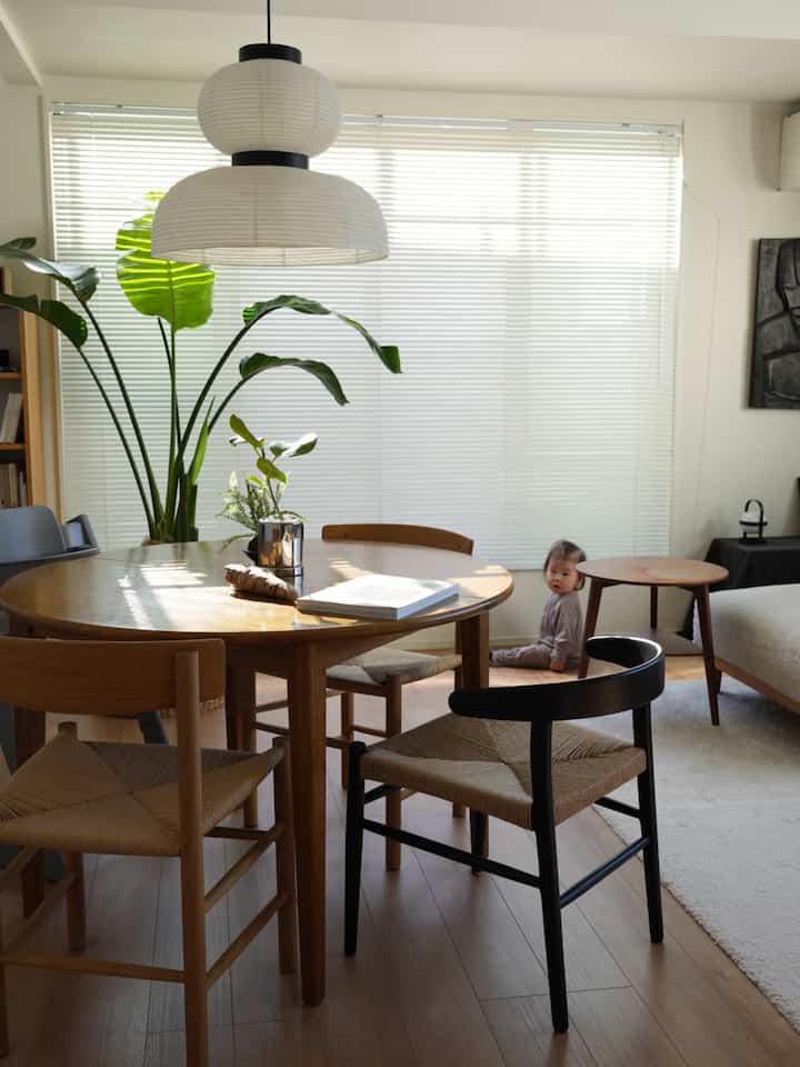 白と木目調のダイニングルーム、自然なダイニングテーブルと椅子が配置された温かみのある空間