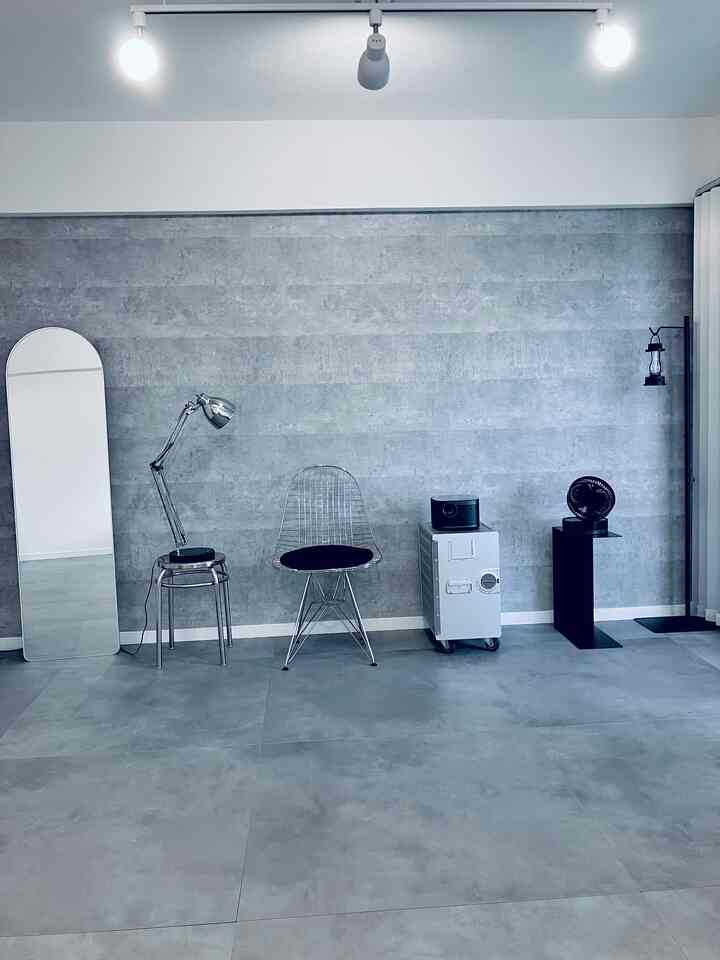 Monotone gray inorganic-style living room featuring stainless steel stools and a full-length mirror with minimalist arrangement