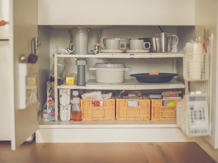 白と茶色の色調が調和するキッチン収納、整然とした食器と食品が美しく配置された印象的な空間