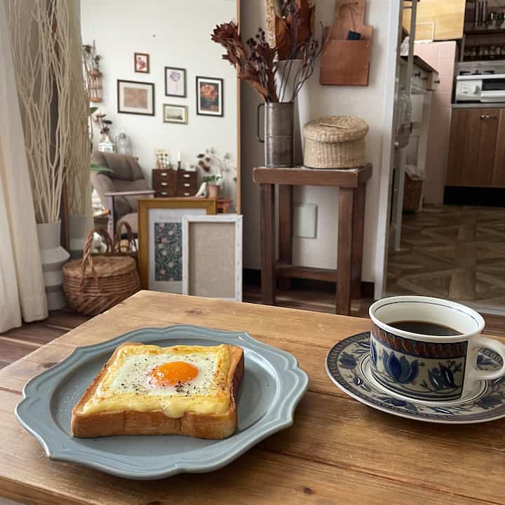 Natural brown toned living and kitchen space featuring wooden table, picture frames, dried flowers, and cozy home cafe vibe