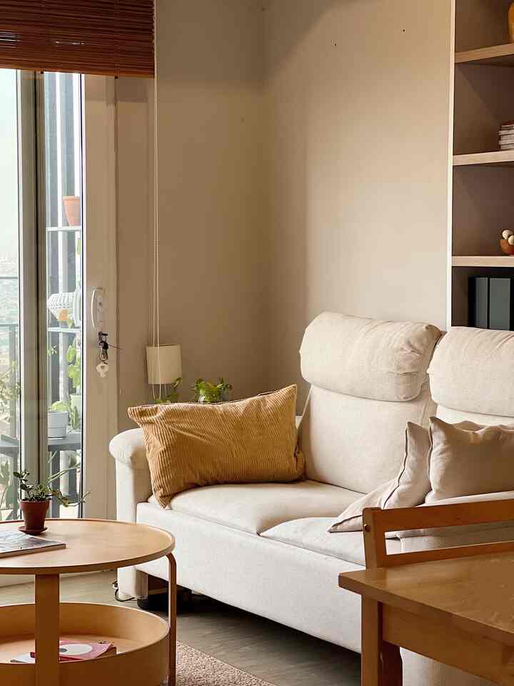 Natural-toned living room with beige sofa and round wooden coffee table, creating a cozy and warm atmosphere