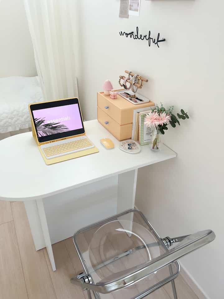 Minimal white and transparent-toned single household home office featuring a clean desk, beige storage drawers, and vase with flowers for a fresh ambiance