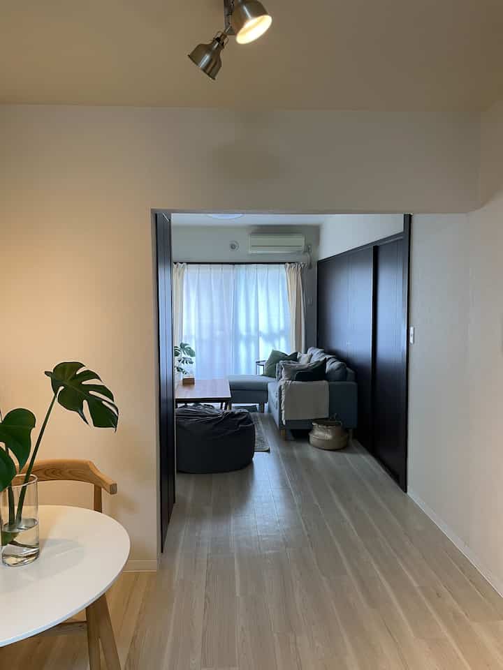 ナチュラルカラーとホワイトトーンのリビングダイニングルーム、ブルーのソファと丸いダイニングテーブルが配置された落ち着いた空間