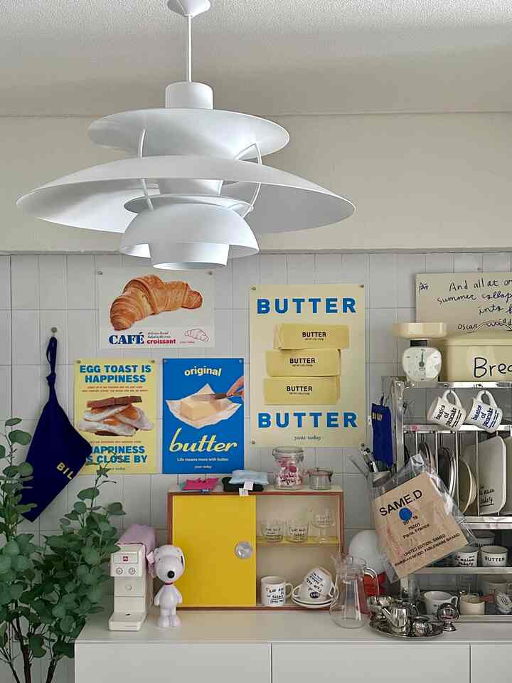 White and yellow toned kitchen space featuring vintage cafe-style posters and coffee items with a cozy atmosphere