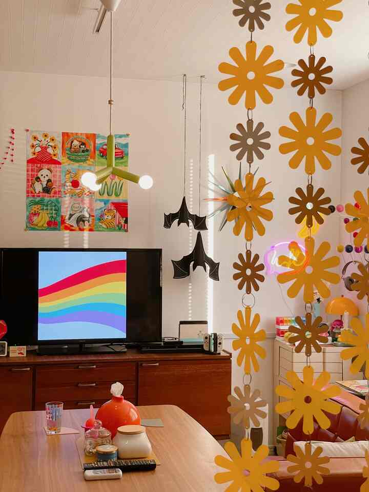 温かみのあるブラウンとイエローのレトロなリビング、ミッドセンチュリーモダンの家具と花の飾りが配置された印象的な空間