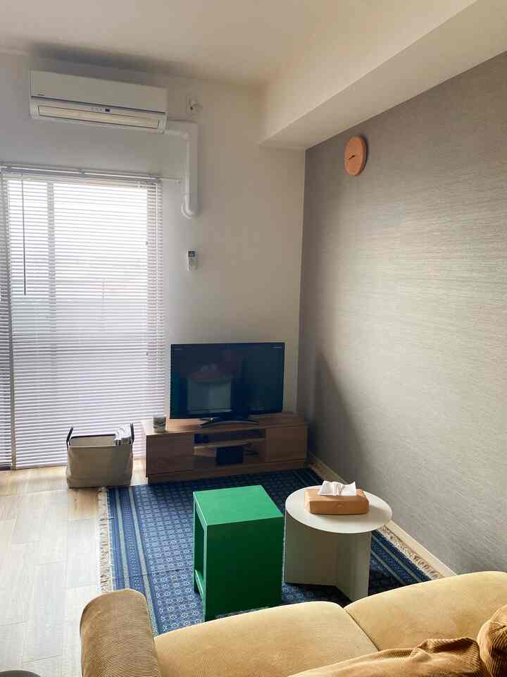 明るいナチュラルカラーのリビング、ソファとテレビ台が配置された落ち着いた雰囲気のインテリア