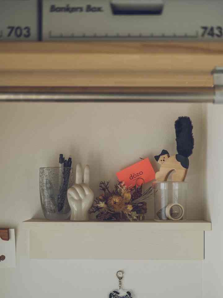 Natural-toned wall shelf displaying cat figurine and dried flowers in a cozy setting