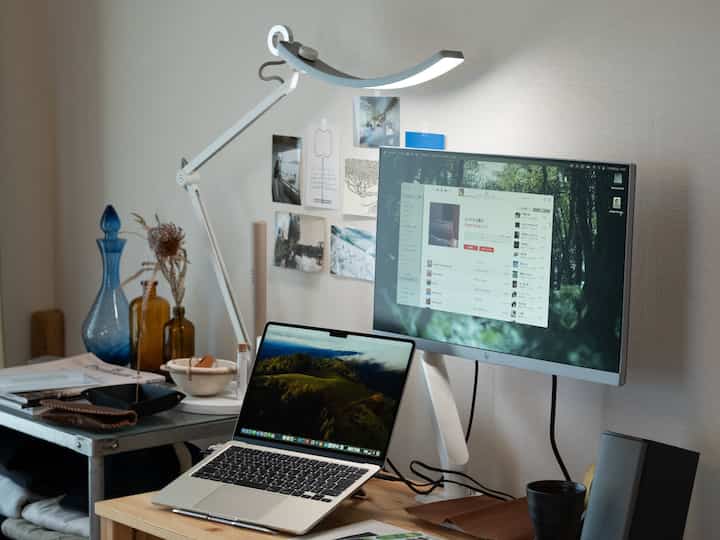 白と茶色のトーンのホームオフィス、ノートパソコンとモニターが配置された実用的でモダンな作業空間