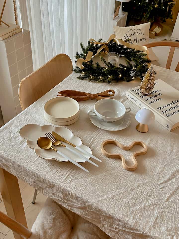 ナチュラルカラーと白を基調としたダイニング、クリスマスの飾りと食器が置かれた雰囲気のある空間