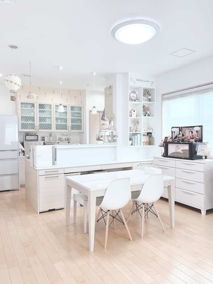 白とナチュラルトーンのダイニング、ダイニングテーブルとチェア、チェストが配置された明るく清潔感のあるインテリア