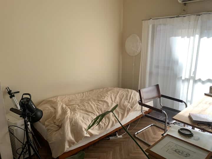 ベージュ色調の寝室、無印良品の寝具と木目調家具が配置された自然でミニマルなインテリア