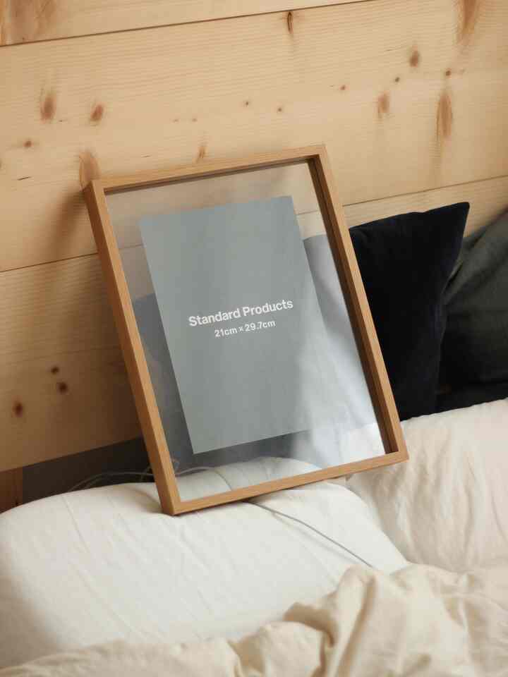 木目調の壁と木製額縁が配置された、温かみのある寝室風の印象的な空間