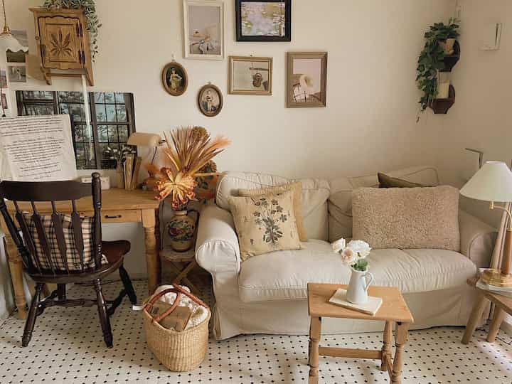 ベージュと木目調の調和が取れたリビング、快適なソファとデスクが配置された雰囲気のあるヴィンテージ空間