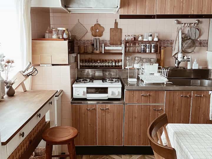 ナチュラルな木目調とベージュタイルが調和した雰囲気のあるカフェ風キッチンとダイニングスペース