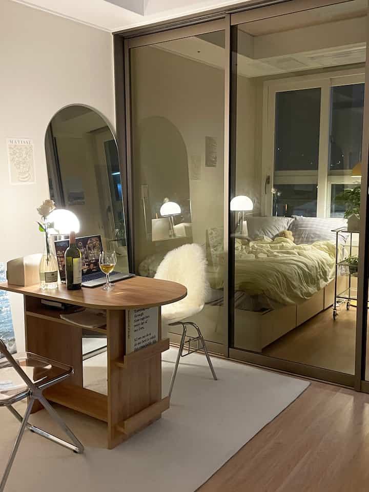 Natural modern small bedroom featuring wood-tone desk and bed creating a cozy atmosphere