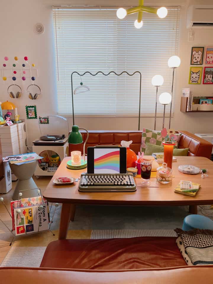 Beige walls and brown leather sofa with a wooden dining table and various accessories forming a cozy retro-style living room