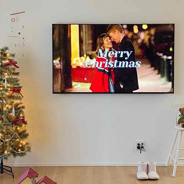 白とゴールドの色調のリビング、クリスマスツリーとテレビが配置され、暖かな雰囲気のあるインテリア