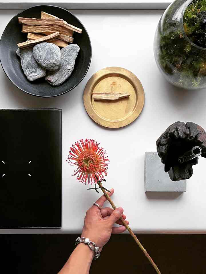White desk featuring black book cover and natural material objets arranged neatly in a clean workspace