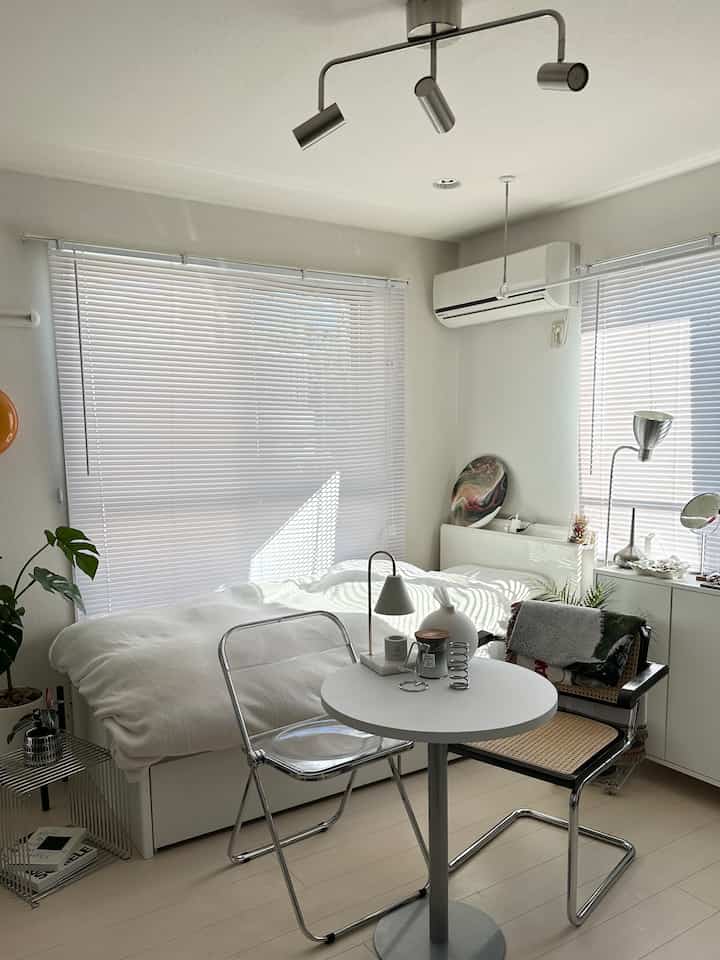 ホワイトとシルバーのトーンが特徴のコンパクトな一人暮らし用寝室、シンプルでミニマルな印象の空間