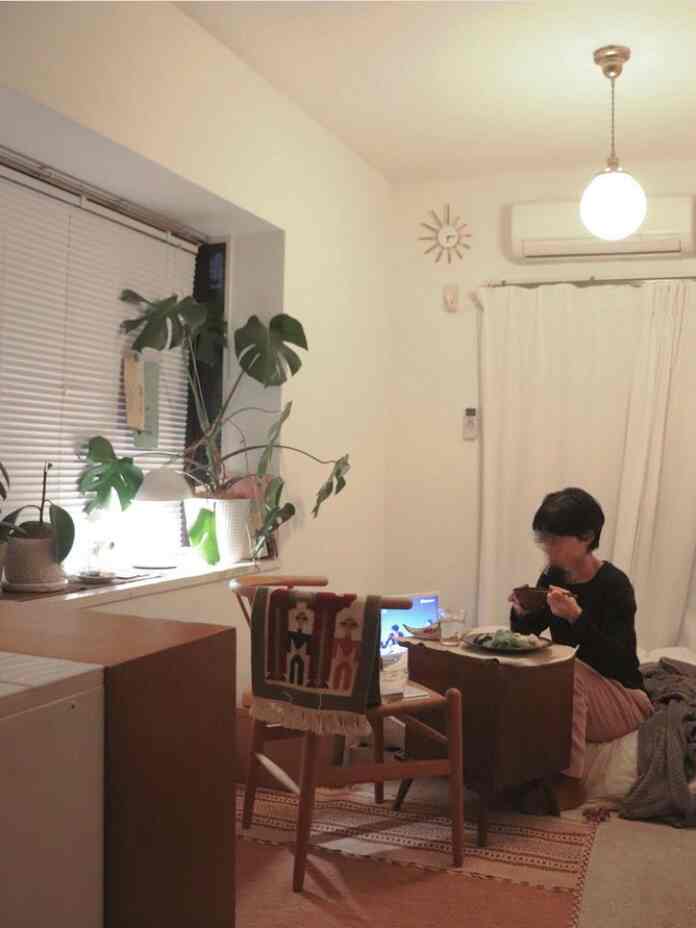 Natural toned small living room with cozy side table and wooden chair arranged for comfortable atmosphere