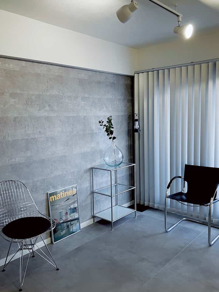 Gray and silver toned mid-century modern living room featuring metallic chairs and side table in a clean, minimalist space