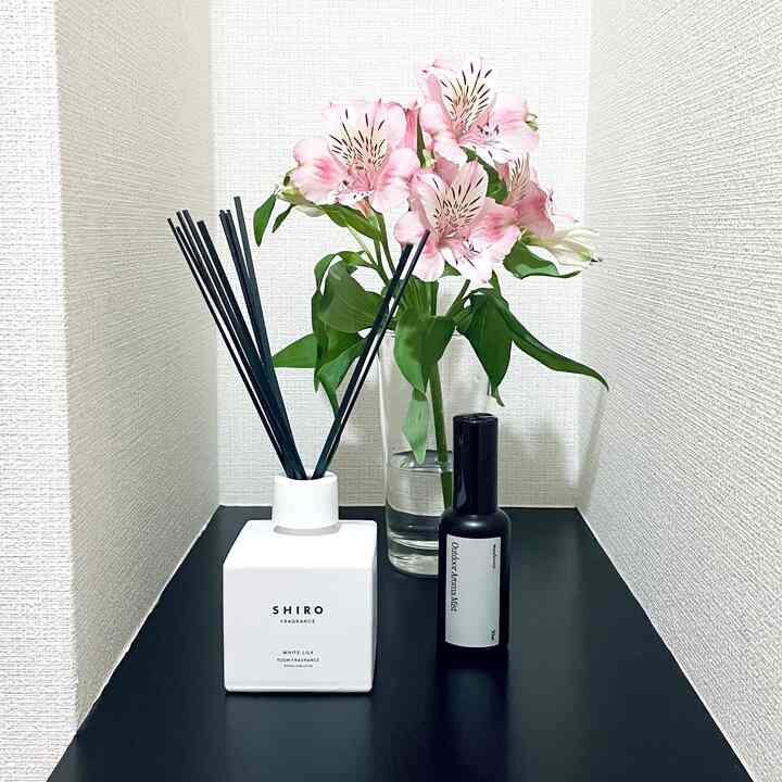 白と黒のモノトーンのコーナースペースにディフューザーと花瓶が置かれた、清潔で落ち着いた雰囲気のインテリア