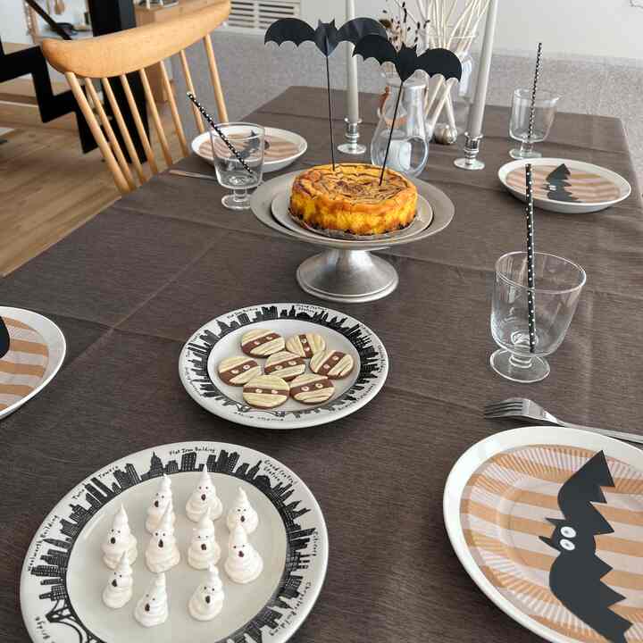 ブラウン色調のダイニングテーブルにハロウィン飾りとデザートが配置された、雰囲気のあるホームパーティースペース
