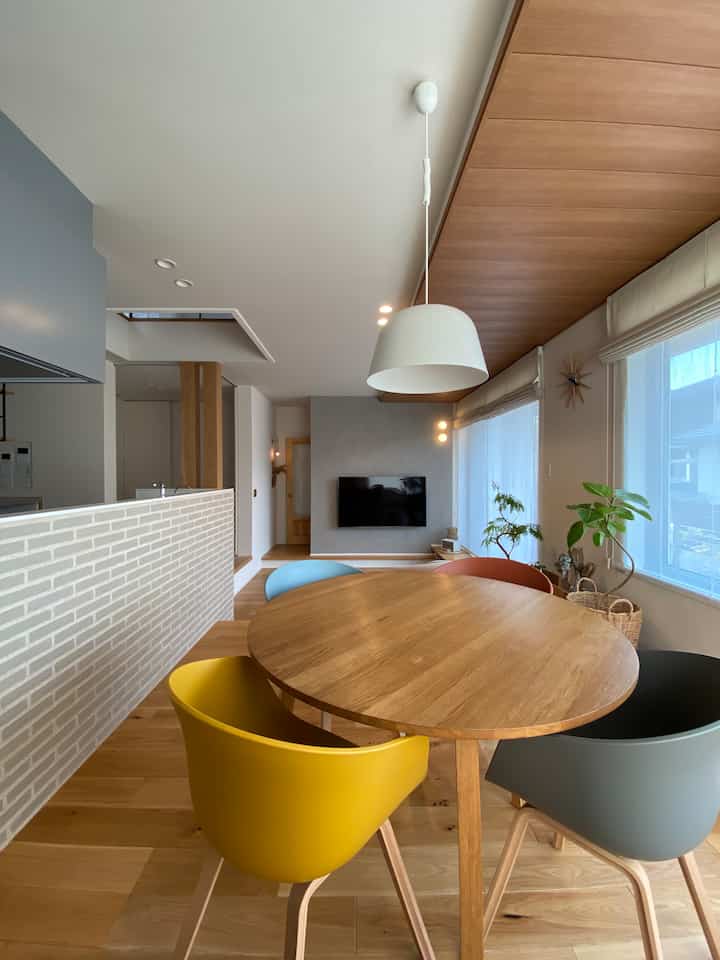 Bright modern living and dining space for 4-person household featuring white walls and wood tones