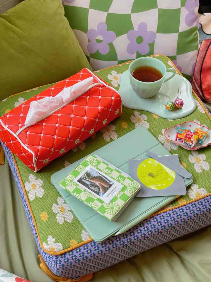 緑色を基調とした寝室、花柄クッションとトレイに置かれたティーカップが配置された雰囲気のあるレトロな空間