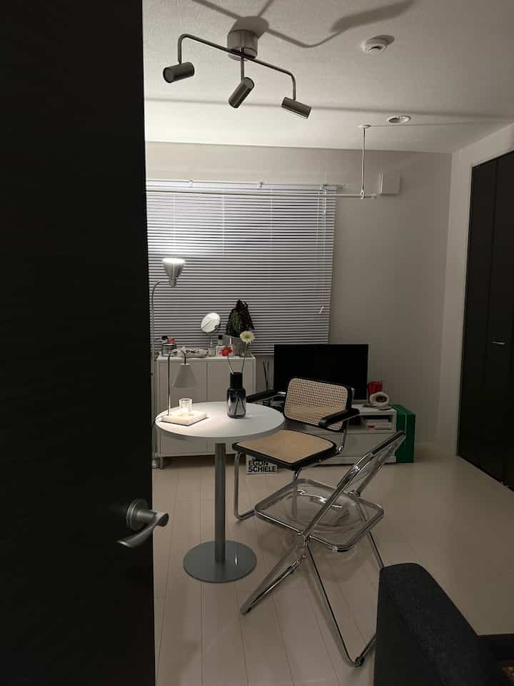 白とネイビーのリビング、丸テーブルとアームチェア、フロアランプが温かい雰囲気を演出