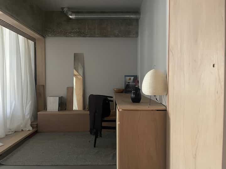 ナチュラルトーンのワークスペース、YチェアとAKARIスタンドランプが配置されたシンプルで落ち着いた雰囲気のインテリア